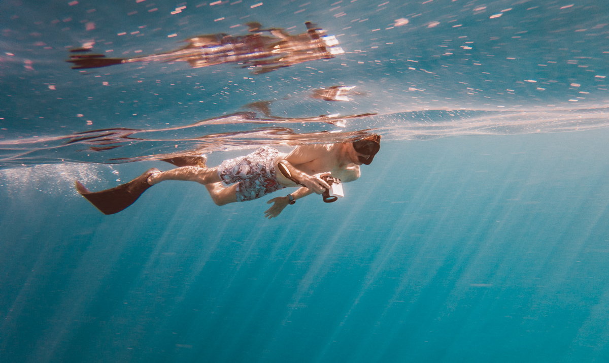 jason wynn snorkeling through rays of light in french polynesia