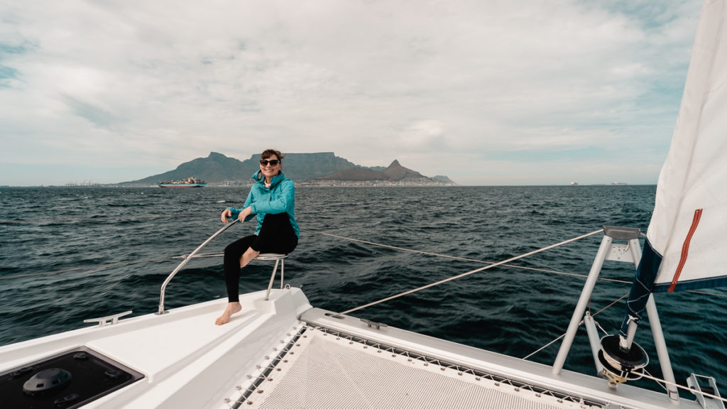 nikki wynn on the bow of a leopard catamaran with cape town south africa in background